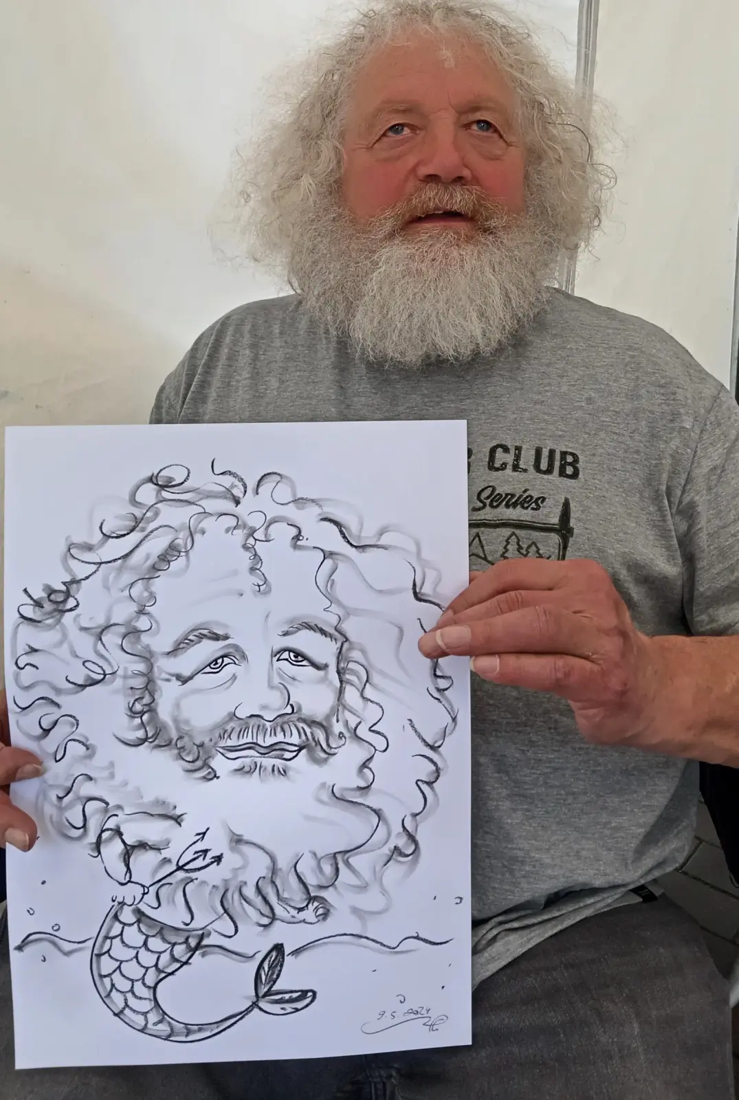 Mann.mit weißem bart haelt seine karikatur als poseidon von event illustrator wuppertal